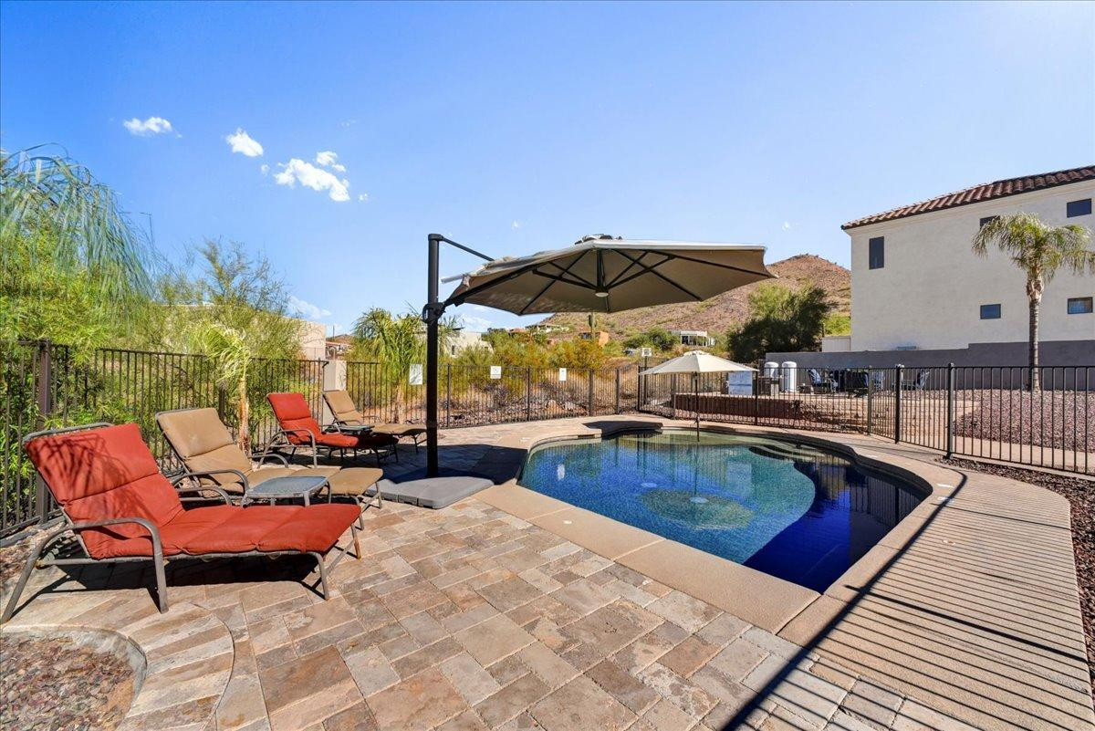 412 East Yearling Road Phoenix, AZ 85085 - Photo 37 of 51 a outdoor space with patio the couches and pool dining table and chairs with an umbrella