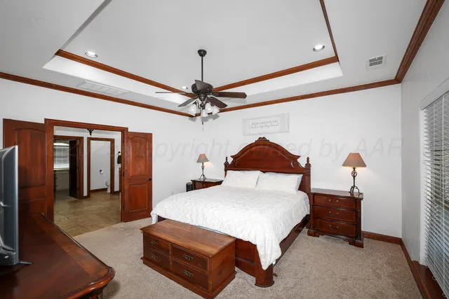 a bedroom with a bed and a flat tv screen on dresser