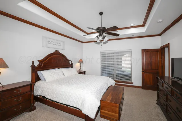 a bedroom with a bed a dresser and flat screen tv