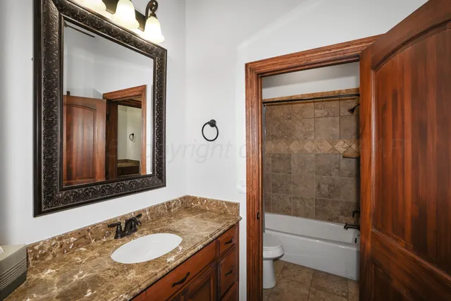 a bathroom with a granite countertop sink toilet and shower