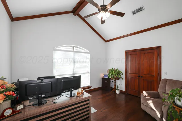 a view of a workspace with furniture and a window