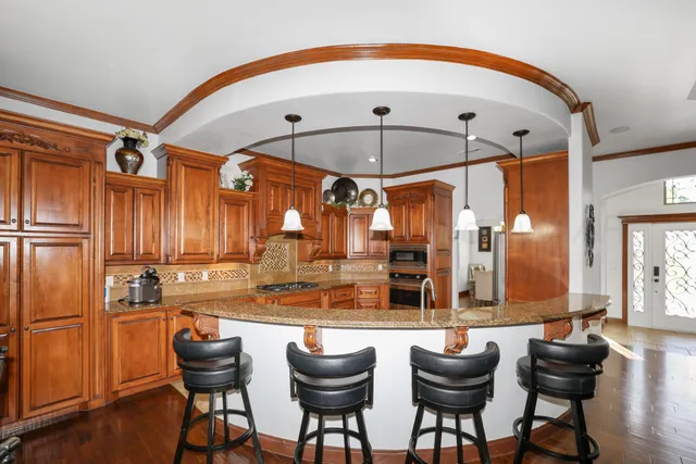 a kitchen with stainless steel appliances kitchen island granite countertop a table and chairs in it