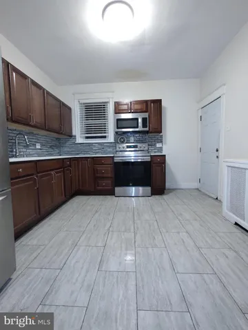 an empty room with ceiling fan and window