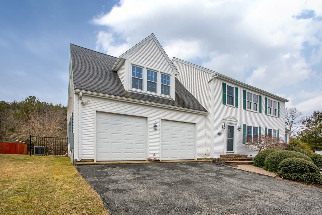 2 Desmond Road Bourne, MA 02561 - Photo 2 of 26 a front view of a house with a yard and garage