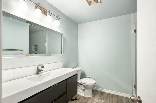 a bathroom with a sink a toilet and a mirror