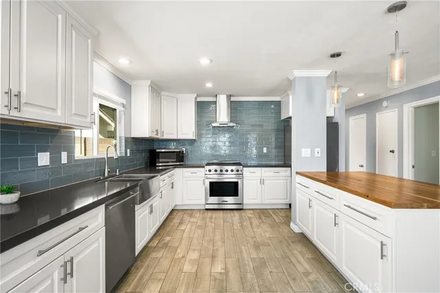 a large kitchen with stainless steel appliances granite countertop a stove a sink and a granite counter tops
