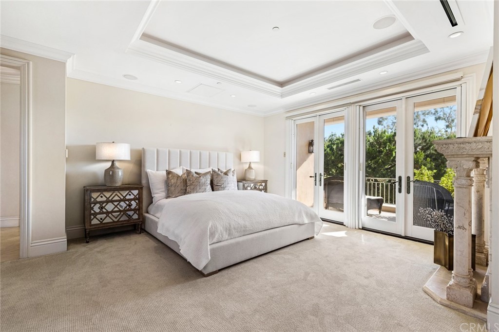 3 Burning Tree Circle Newport Beach, CA 92660 - Photo 36 of 65 a spacious bedroom with a bed and large mirror next to a window