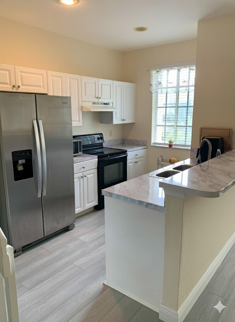 2007 Nassau Drive Riviera Beach, FL 33404 - Photo 5 of 13 a kitchen with stainless steel appliances granite countertop a refrigerator a stove a sink and a microwave