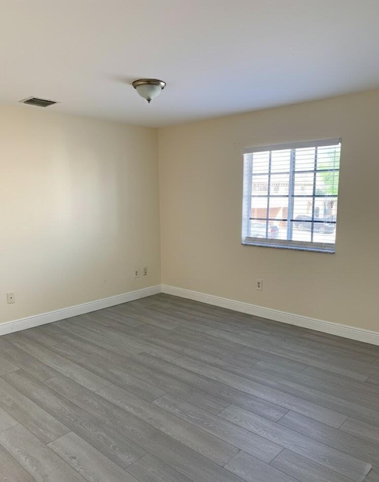 2007 Nassau Drive Riviera Beach, FL 33404 - Photo 9 of 13 wooden floor in an empty room with a window