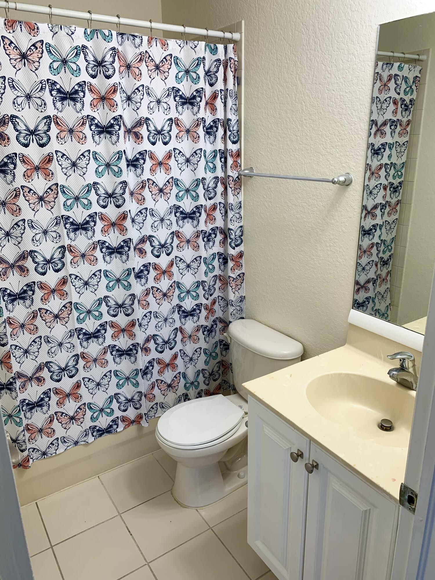 2007 Nassau Drive Riviera Beach, FL 33404 - Photo 10 of 13 a white toilet sitting next to a shower curtain