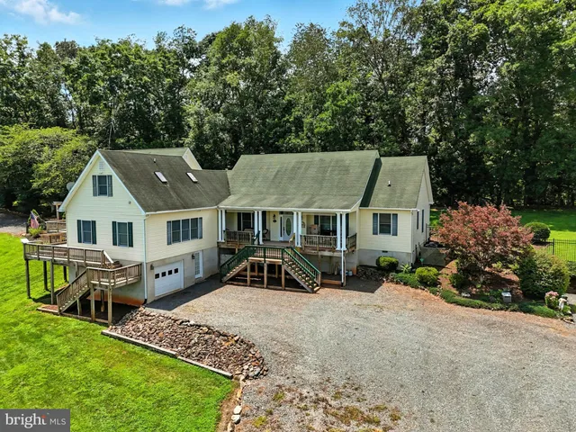 an aerial view of a house with table and chairs under an umbrella