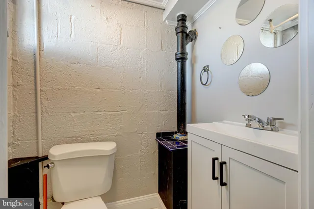 a bathroom with a sink vanity mirror and toilet