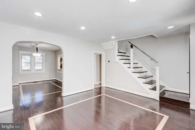 an entryway in a hall with a window and wooden floor