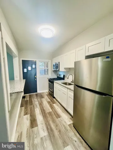 a kitchen with a refrigerator a stove top oven a sink and dishwasher