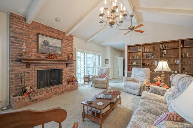 a living room with furniture a chandelier and a fireplace