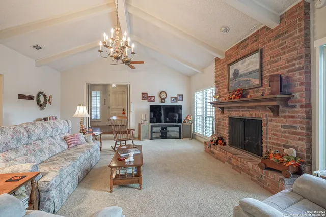a view of a dining room with furniture a chandelier and window