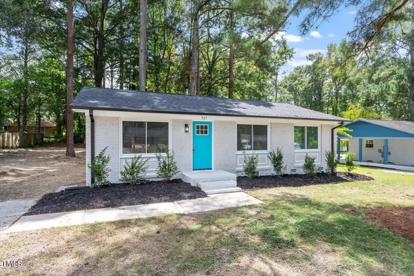 a front view of a house with a garden and patio