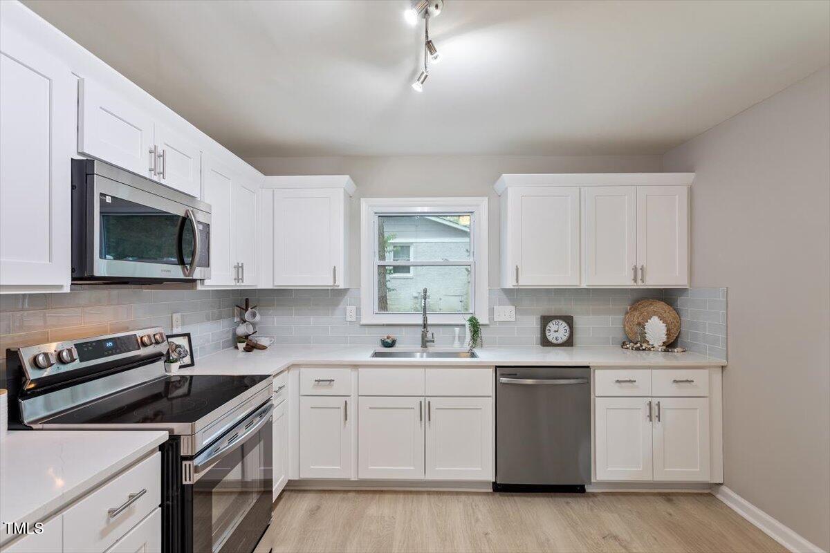507 Forest Ridge Road Garner, NC 27529 - Photo 11 of 33 a kitchen with a sink stove and microwave
