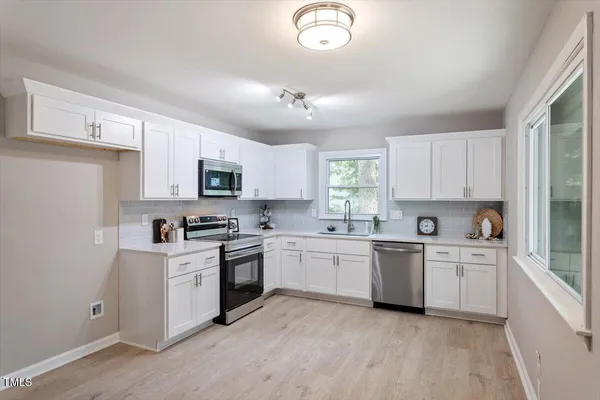 a kitchen with cabinets a sink and appliances