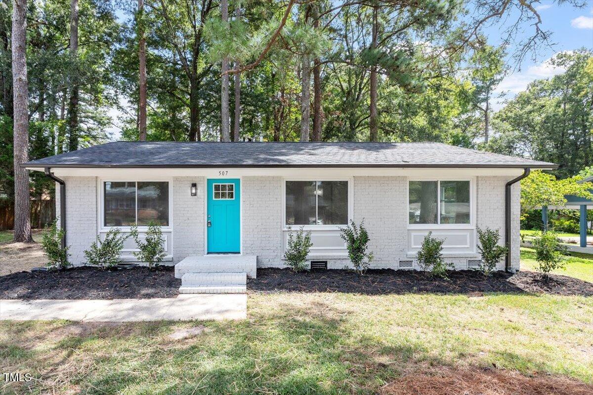 507 Forest Ridge Road Garner, NC 27529 - Photo 25 of 33 a front view of a house with a yard and potted plants