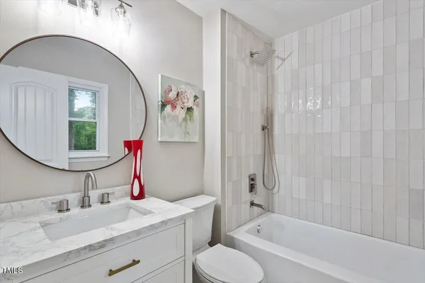a bathroom with a granite countertop sink mirror vanity and toilet