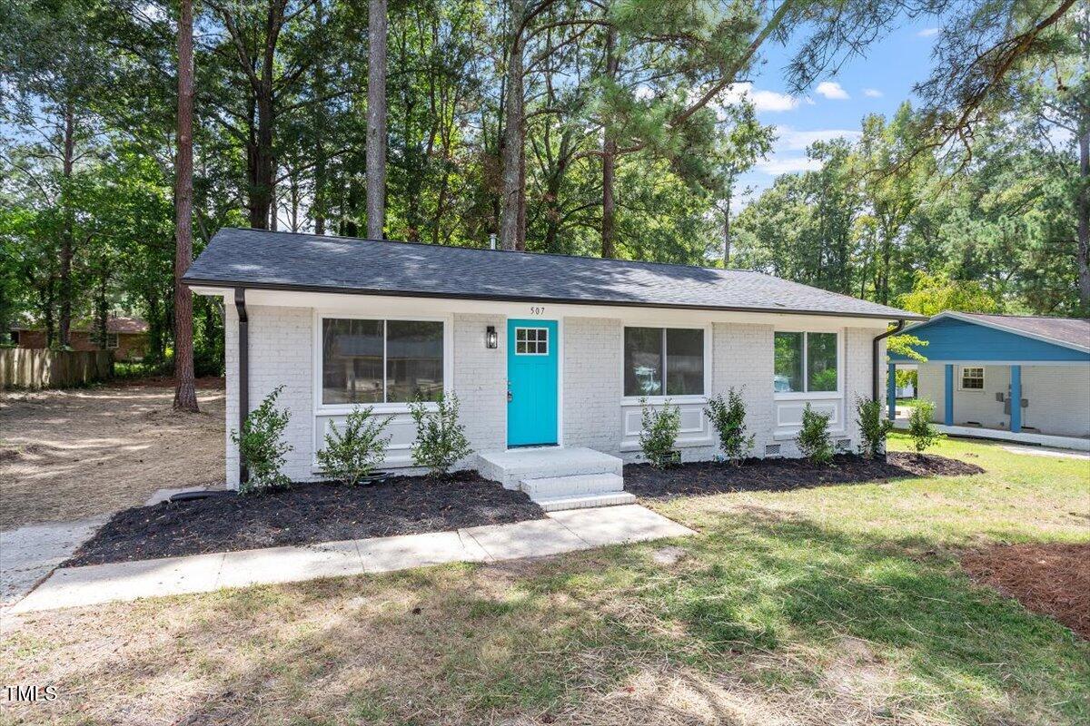 507 Forest Ridge Road Garner, NC 27529 - Photo 3 of 33 a front view of a house with a garden and patio