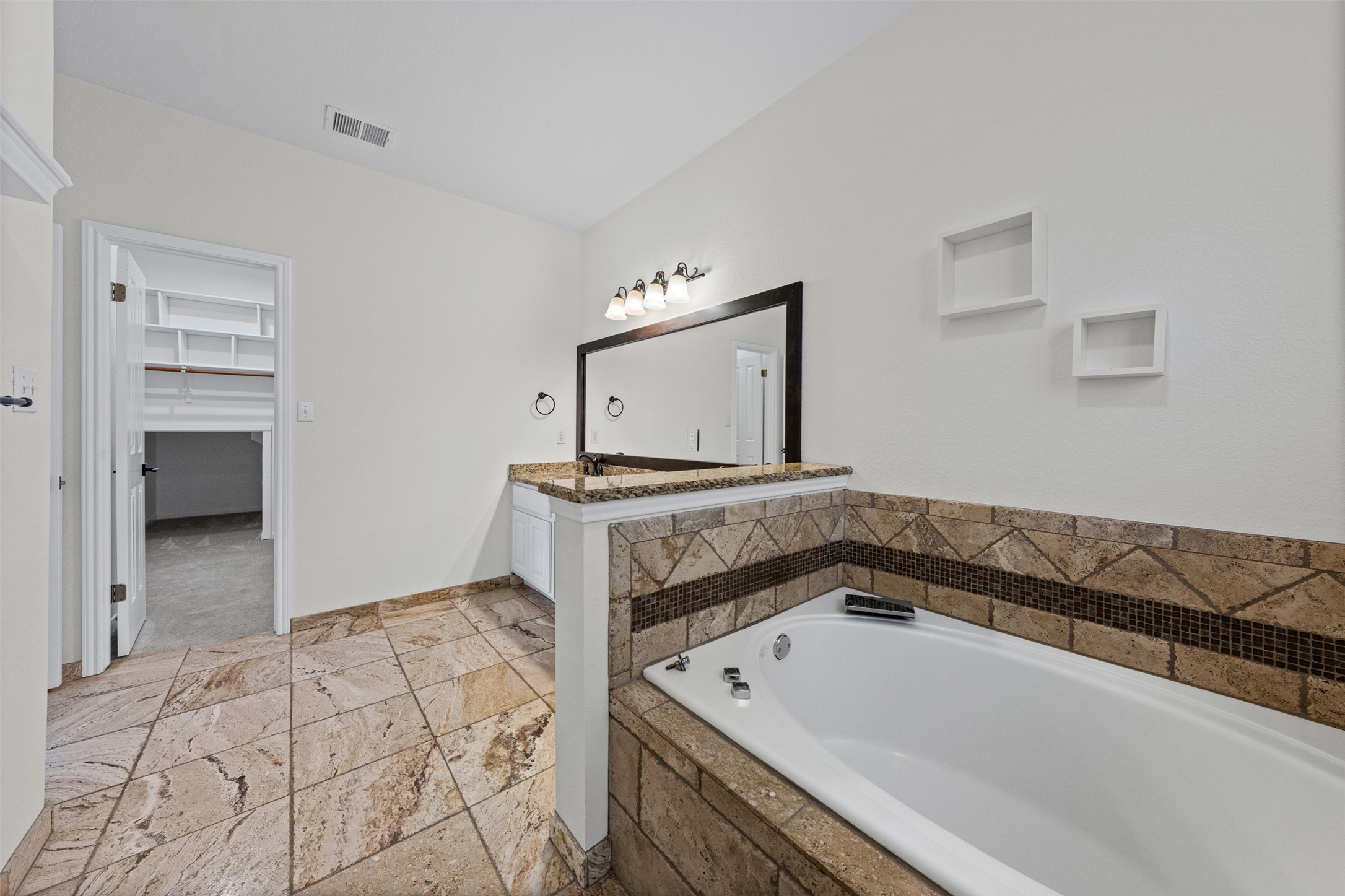 8820 Colberg Drive Austin, TX 78749 - Photo 19 of 35 Luxurious soaker tub and elegant vanity in this well-appointed primary bathroom.