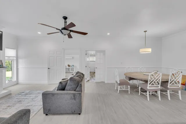 a living room with furniture and a ceiling fan