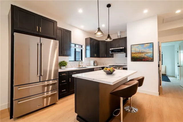 a kitchen with a refrigerator a sink and chairs
