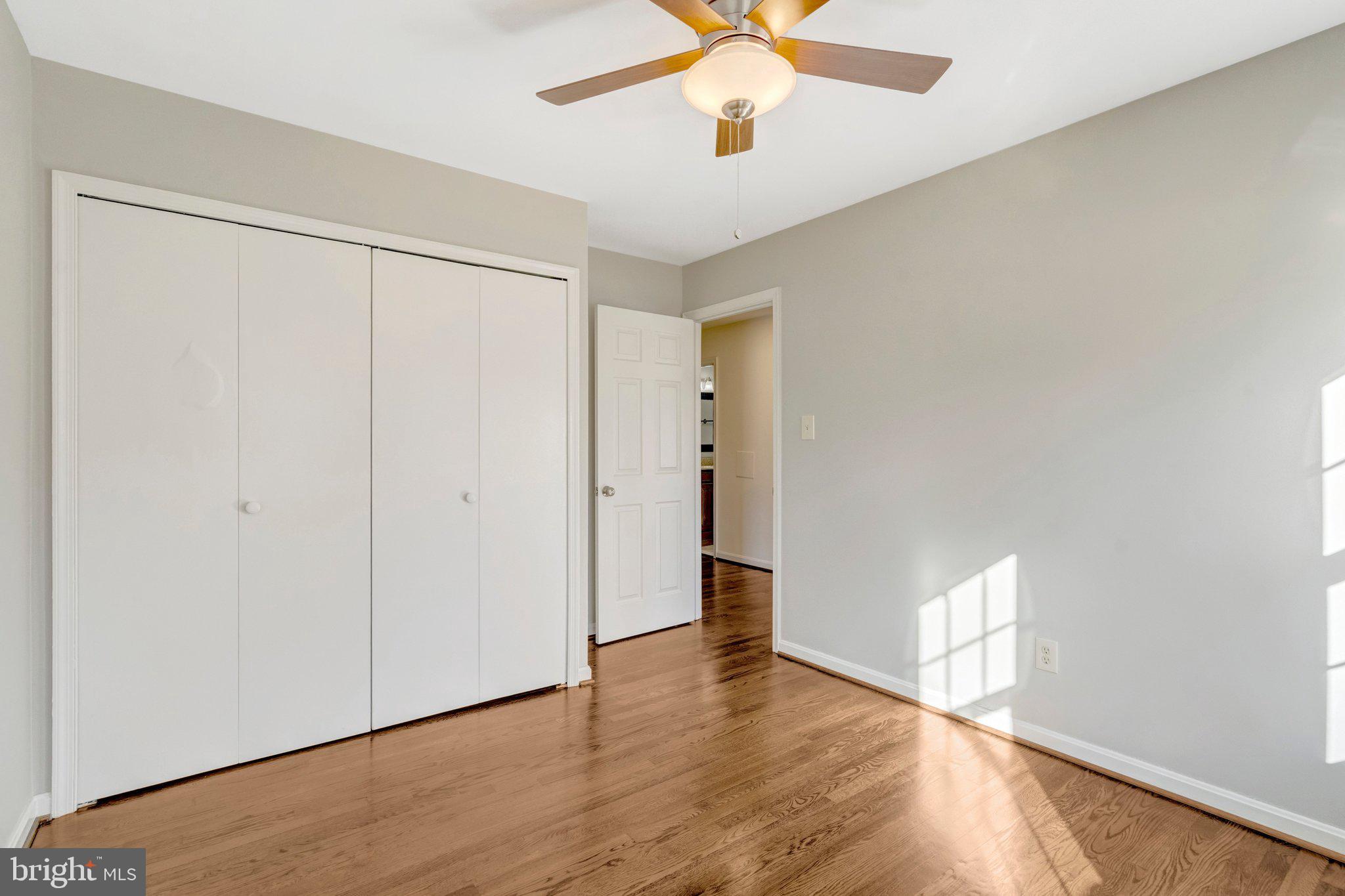 9315 Winbourne Road Burke, VA 22015 - Photo 19 of 51 an empty room with wooden floor closet and windows
