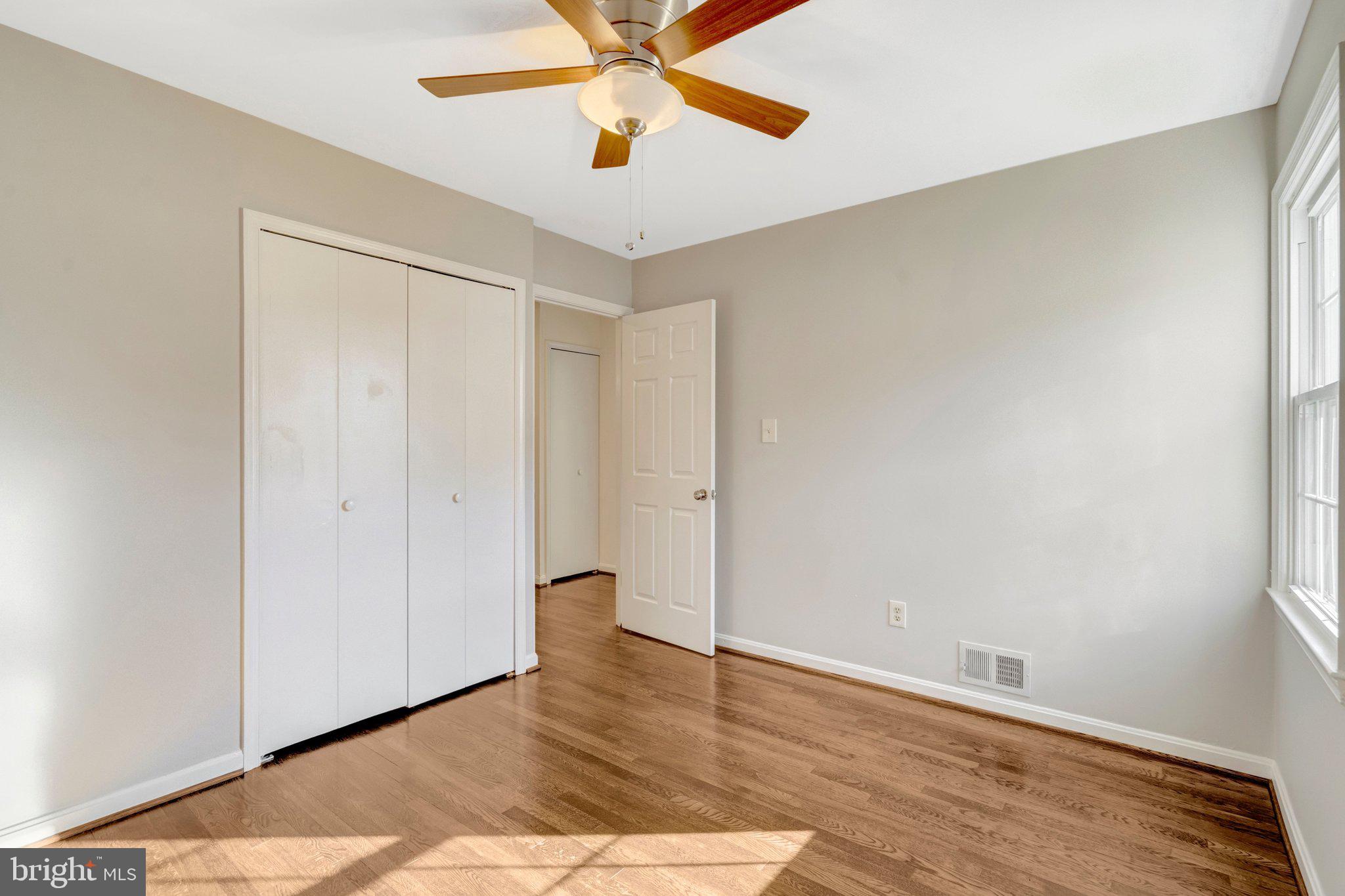 9315 Winbourne Road Burke, VA 22015 - Photo 21 of 51 an empty room with wooden floor closet and windows