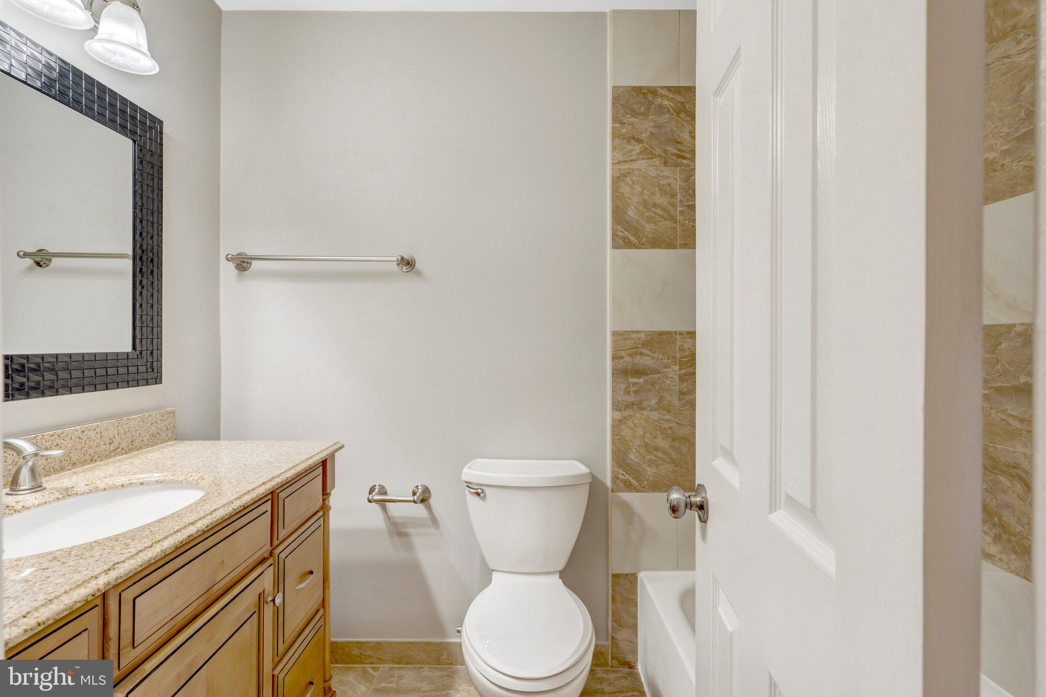 9315 Winbourne Road Burke, VA 22015 - Photo 22 of 51 a bathroom with a granite countertop toilet sink and a mirror