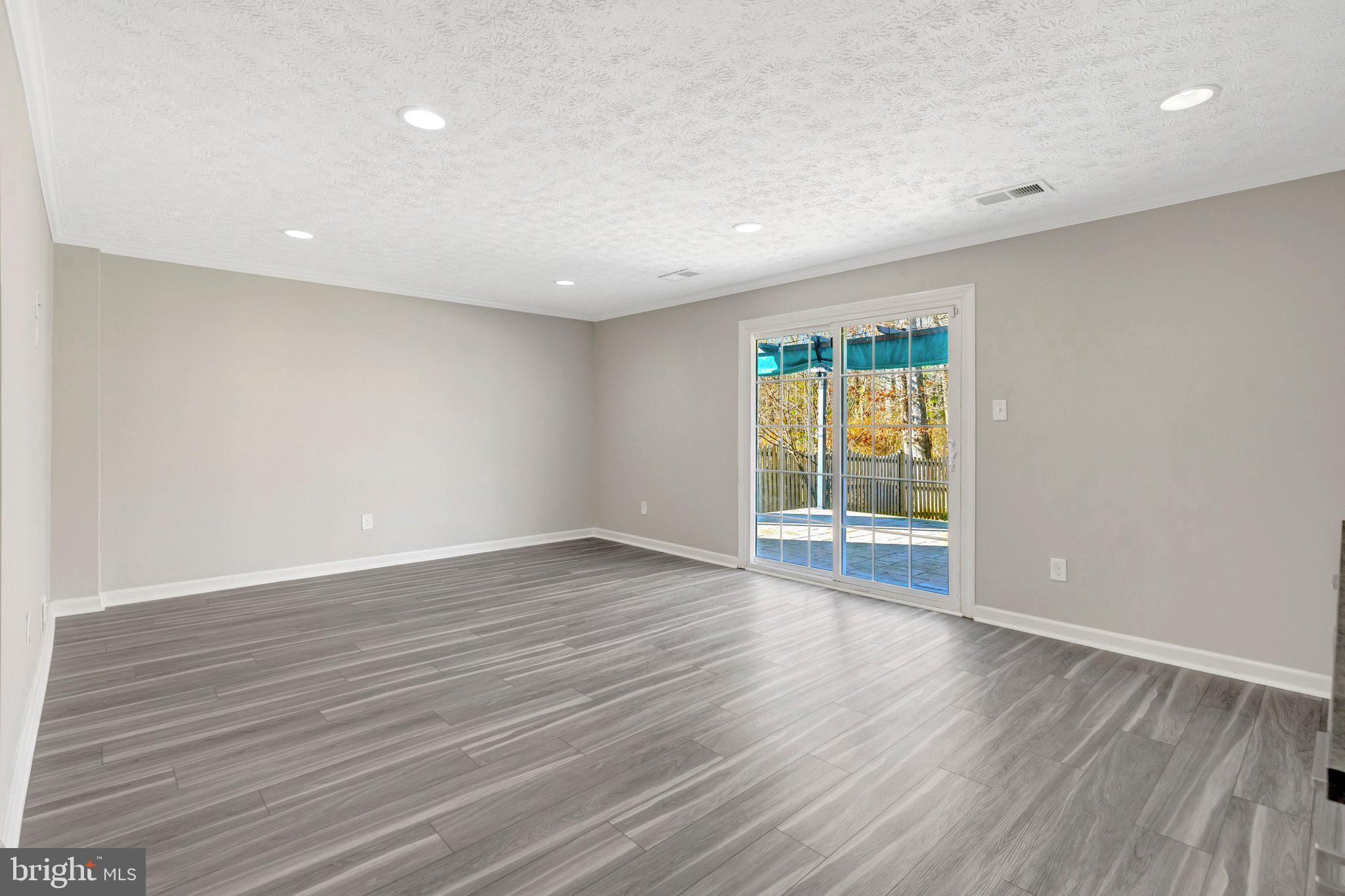 9315 Winbourne Road Burke, VA 22015 - Photo 29 of 51 a view of an empty room with wooden floor and a window