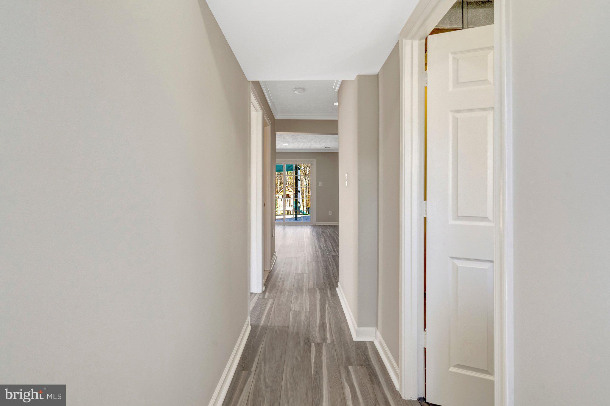 9315 Winbourne Road Burke, VA 22015 - Photo 34 of 51 a view of a hallway with wooden floor and a bathroom