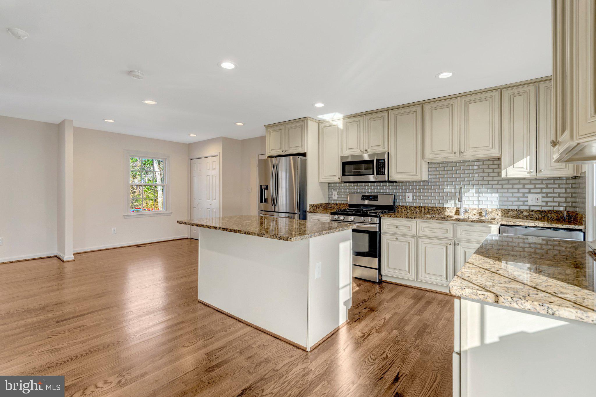 9315 Winbourne Road Burke, VA 22015 - Photo 8 of 51 a kitchen with granite countertop a refrigerator and a stove top oven