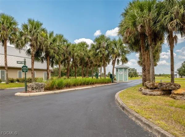 a view of a street with a building and palm trees