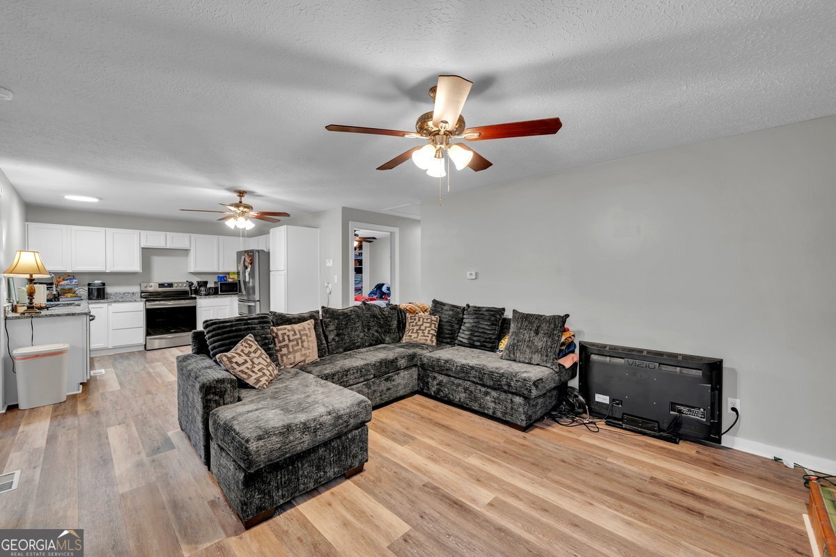 418 Flintside Drive Cobb, GA 31735 - Photo 11 of 45 a living room with furniture and a chandelier