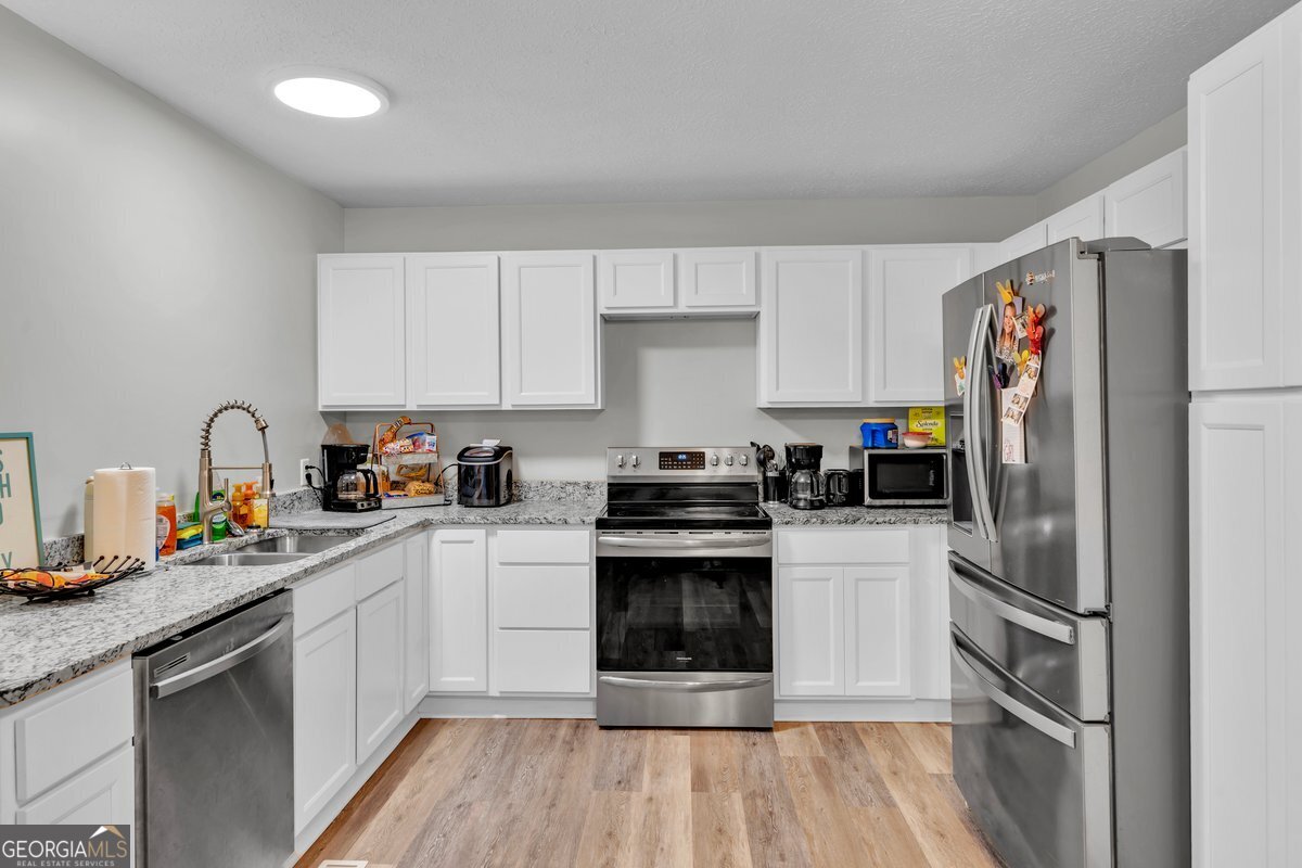 418 Flintside Drive Cobb, GA 31735 - Photo 12 of 45 a kitchen with a refrigerator stove and sink