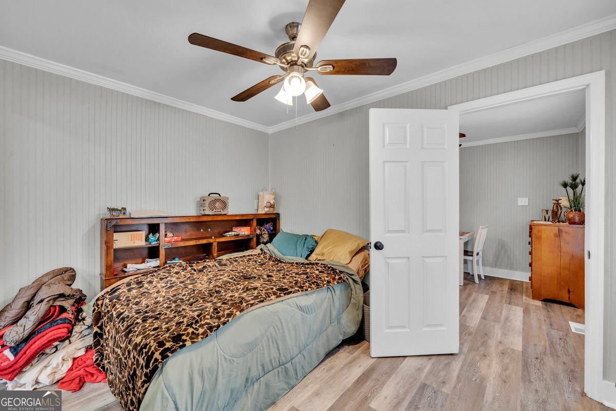 418 Flintside Drive Cobb, GA 31735 - Photo 17 of 45 a bedroom with a bed and wooden floor