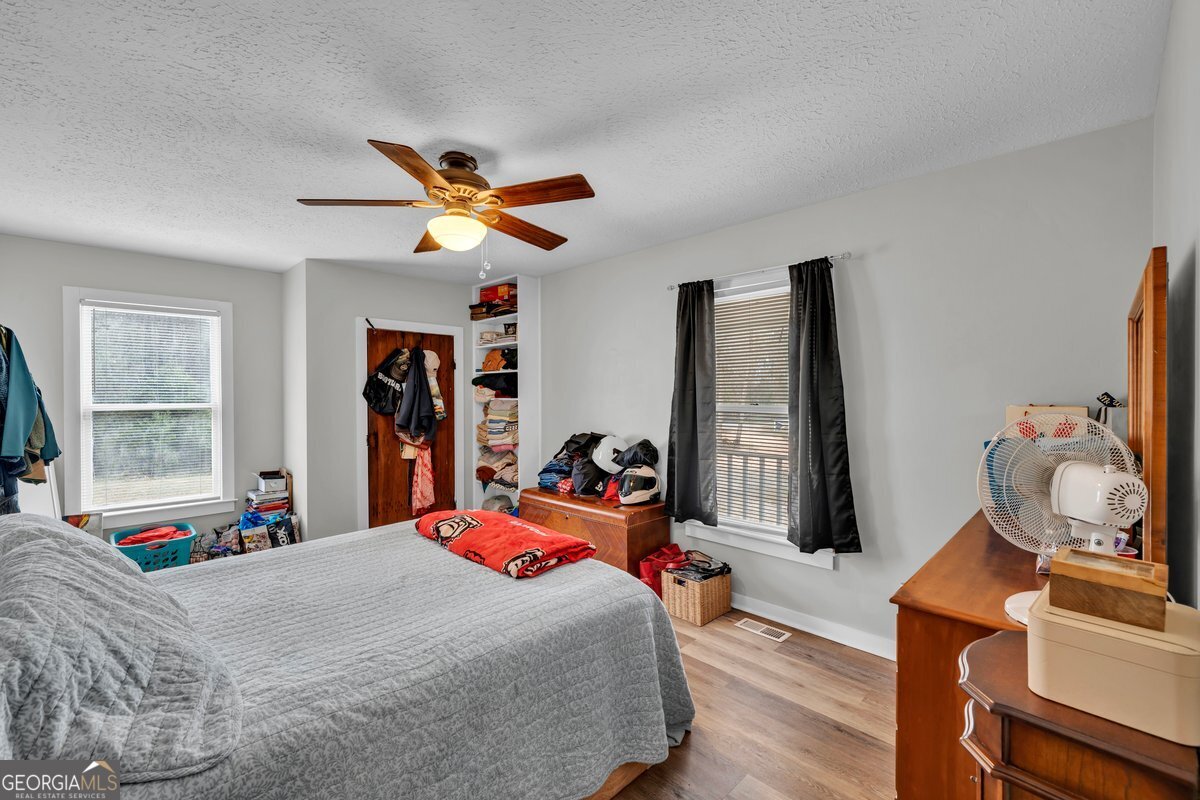 418 Flintside Drive Cobb, GA 31735 - Photo 20 of 45 a bedroom with a bed and a chandelier
