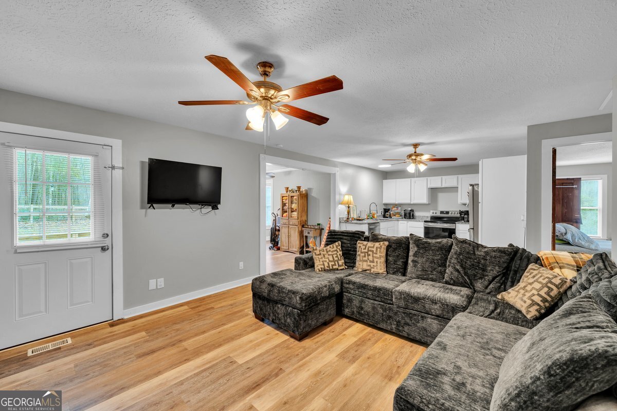 418 Flintside Drive Cobb, GA 31735 - Photo 10 of 45 a living room with furniture a flat screen tv and a window