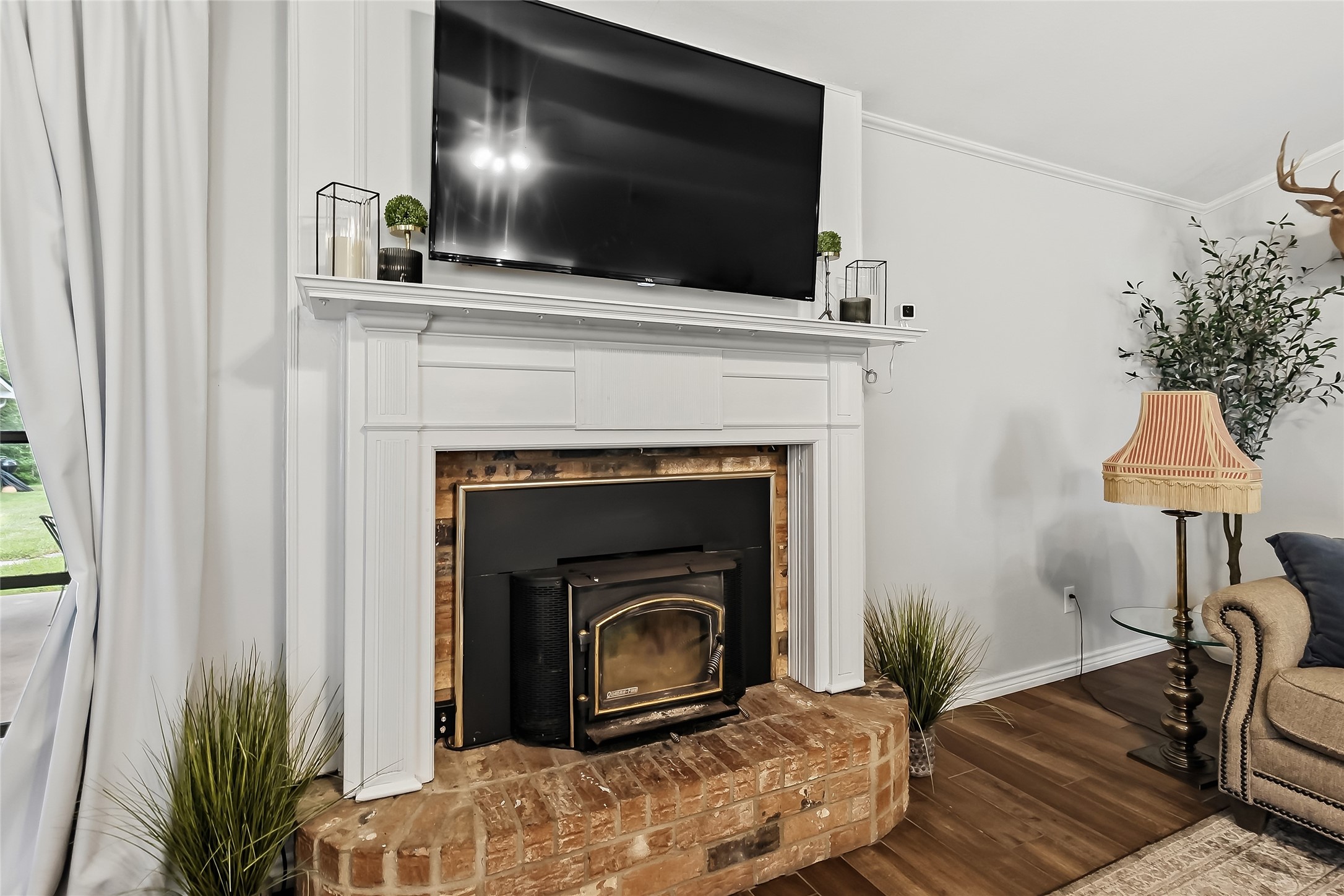 906 Standley Road Madisonville, TX 77864 - Photo 7 of 40 a living room with a fireplace and a flat screen tv
