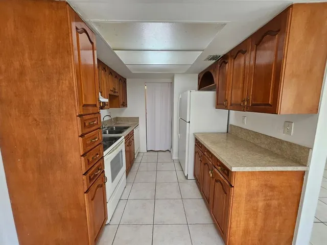 a kitchen with stainless steel appliances granite countertop a refrigerator and a stove