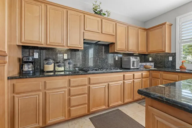 a kitchen with stainless steel appliances granite countertop sink stove top oven and cabinets