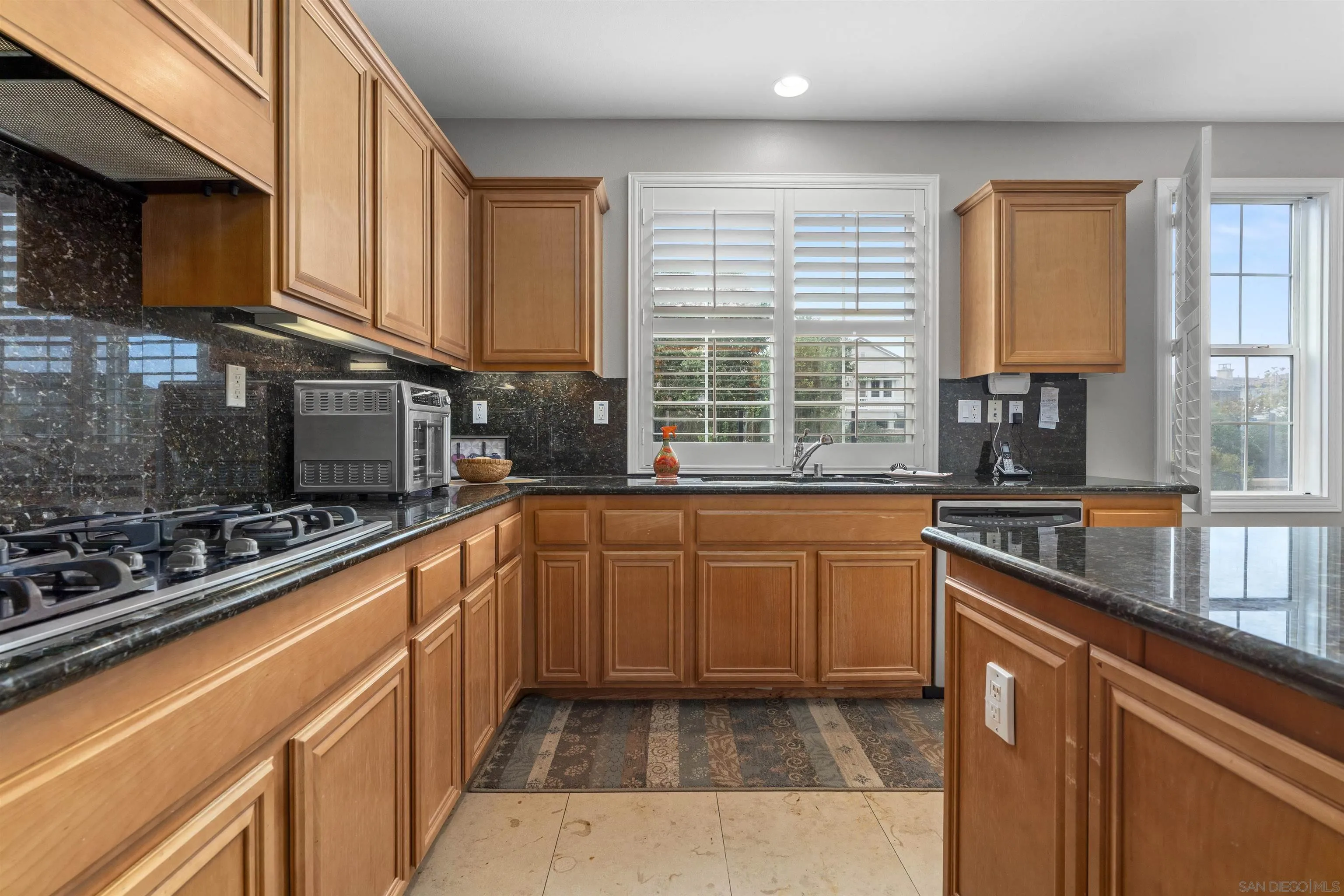 840 Luminara Way San Marcos, CA 92078 - Photo 15 of 57 a kitchen with stainless steel appliances granite countertop sink stove top oven and cabinets