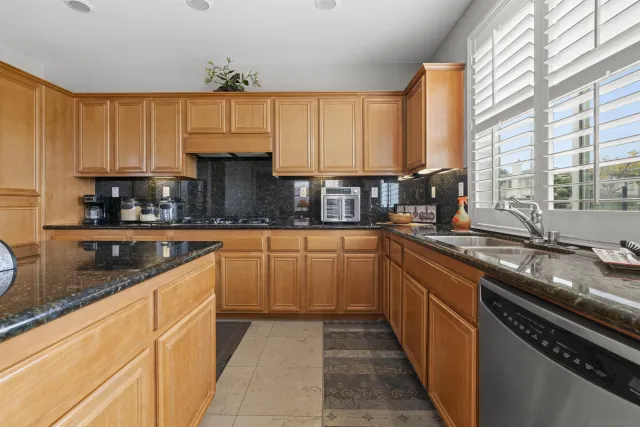a kitchen with granite countertop lots of counter top windows and chairs