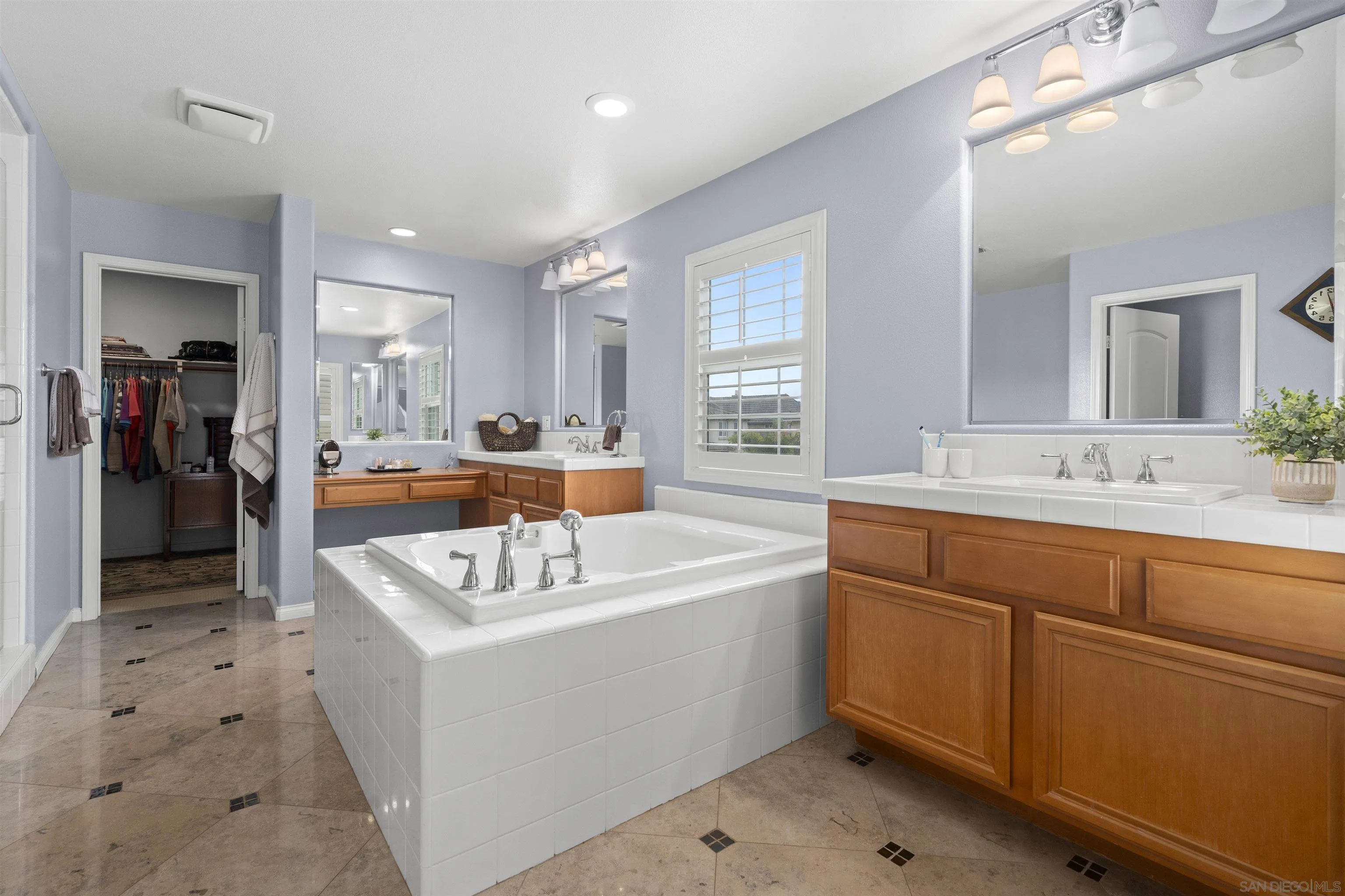 840 Luminara Way San Marcos, CA 92078 - Photo 38 of 57 a spacious bathroom with a sink a mirror and a bathtub