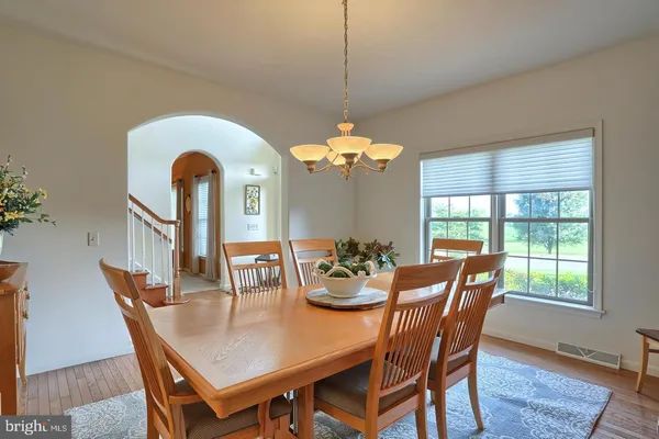 a dining room with furniture a chandelier and wooden floor