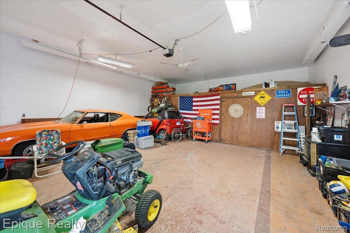 1221 Rhodes Road Lake Orion, MI 48360 - Photo 52 of 72 Spacious garage featuring a ceiling fan, recessed lighting, fluorescent strip lighting, a built-in storage area, and a durable concrete floor with a brick-patterned border