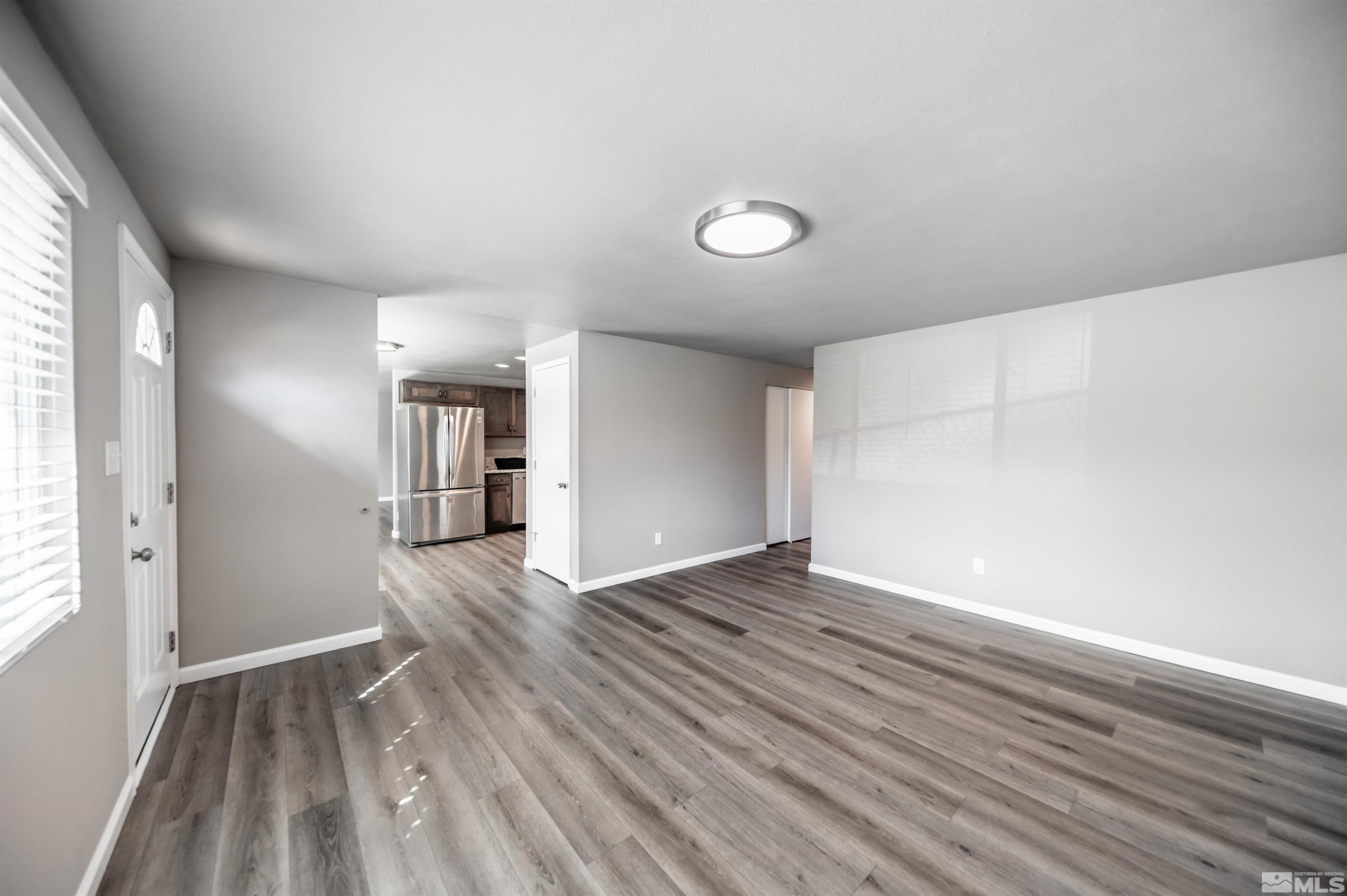495 Kess Court Reno, NV 89506 - Photo 3 of 18 a view of empty room with wooden floor and fan